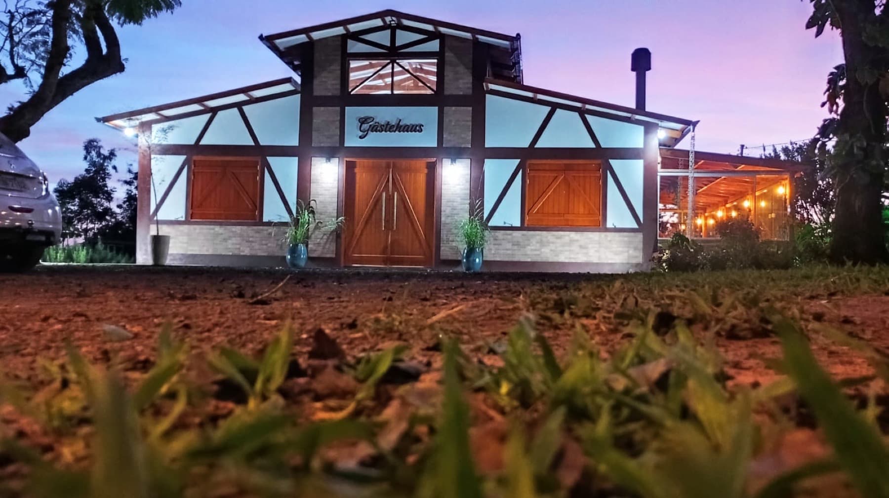 Fachada iluminada da pousada ao anoitecer