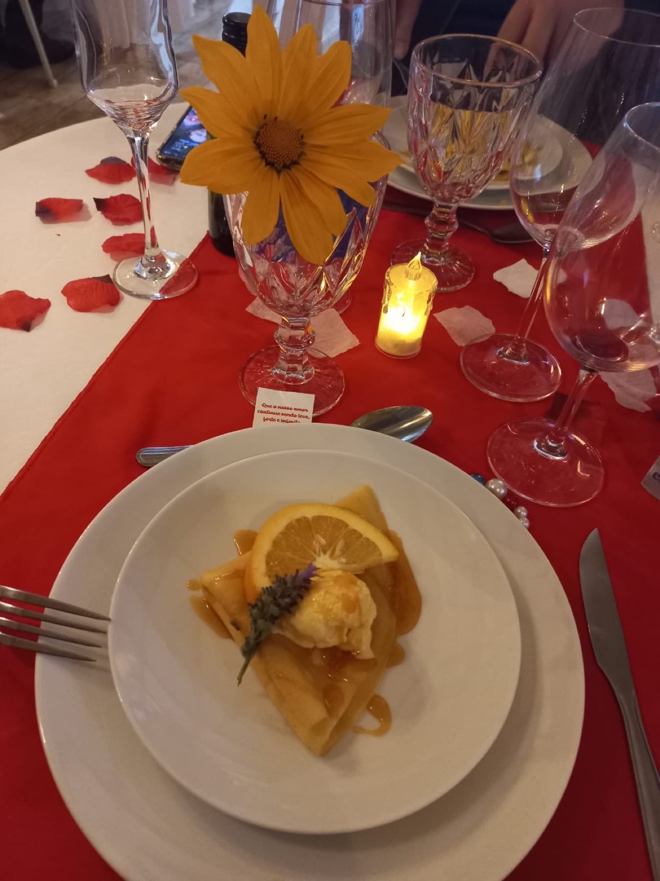 Mesa posta com flor, taças e sobremesa para uma experiência especial